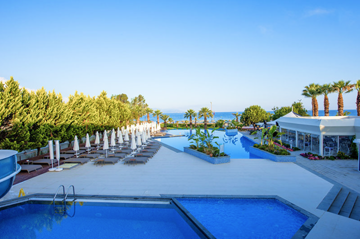 Blick auf den Pool und den Strandbereich des Hotels, ideal für Entspannung und Erholung unter der Sonne.