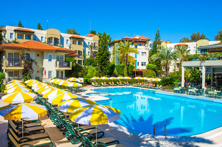 Weitläufiger Pool im Hotel, ausgestattet mit Liegen und Sonnenschirmen für entspannte Stunden am Wasser.