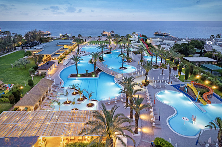 Nachtsicht auf den Hotelpool und den Strand, romantisch beleuchtet und ruhig unter dem nächtlichen Himmel.
