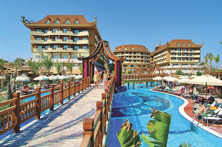 Ein großes Resort mit einem weitläufigen Pool und einem einladenden Gehweg, umgeben von üppiger Vegetation.